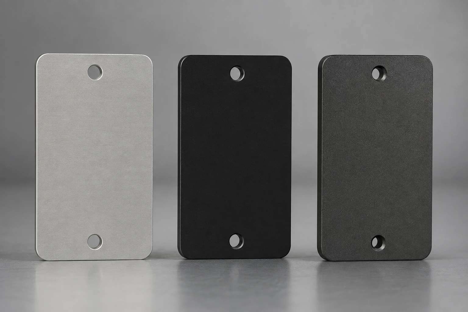 Three aluminum test coupons with natural, black and hard-anodized finishes